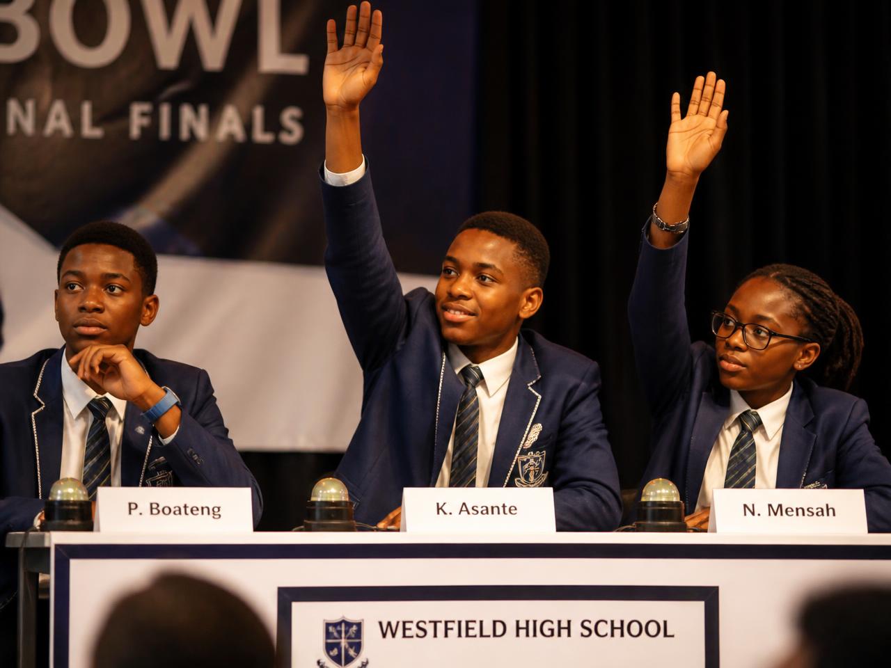 Students answering questions on a quiz competition stage