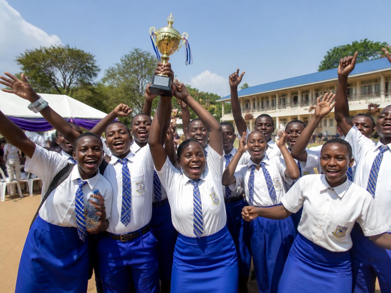 Students celebrating with a trophy after a competition